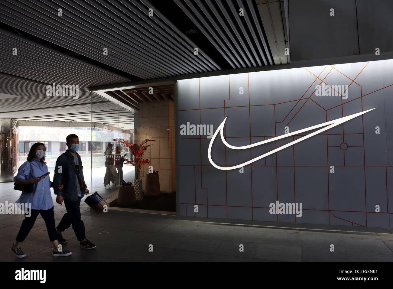 La gente pasa por una tienda del minorista de artículos deportivos Nike Inc  en un complejo comercial en Beijing, China 25 de marzo de 2021. REUTERS/ Florencia lo Fotografía de stock - Alamy