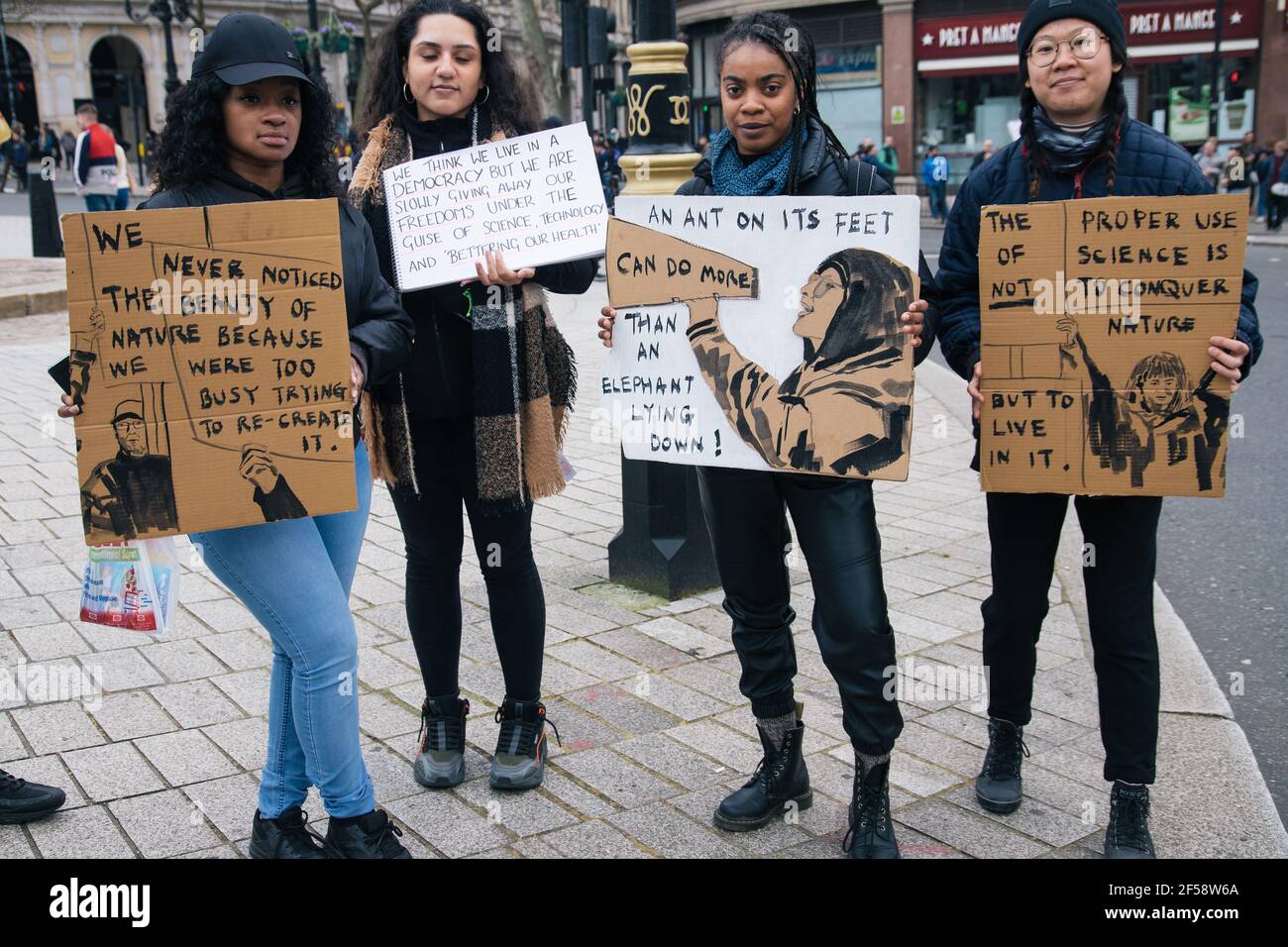 Londres, Reino Unido, 20th de marzo de 2021. Alrededor de 6000 manifestantes contra el bloqueo y la vacunación y contra la Policía, el crimen, la sentencia y los tribunales Bill march en el centro de Londres. La protesta comenzó en Hyde Park con una serie de detenciones y un discurso de Piers Corbyn, que se presenta a la alcaldía de Londres, marchó sin problemas por el centro de Londres y terminó con un puesto de atrás en Hyde Park entre unos 200 manifestantes y la policía antidisturbios restantes. Cuatro mujeres sostienen carteles aludiendo a la crisis ambiental e instando a la gente a levantarse Foto de stock