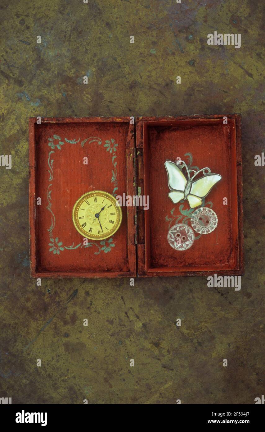 Caja de madera con estampado vintage que contiene una mariposa de reloj con  cara dorada broche y dos botones de cristal Fotografía de stock - Alamy