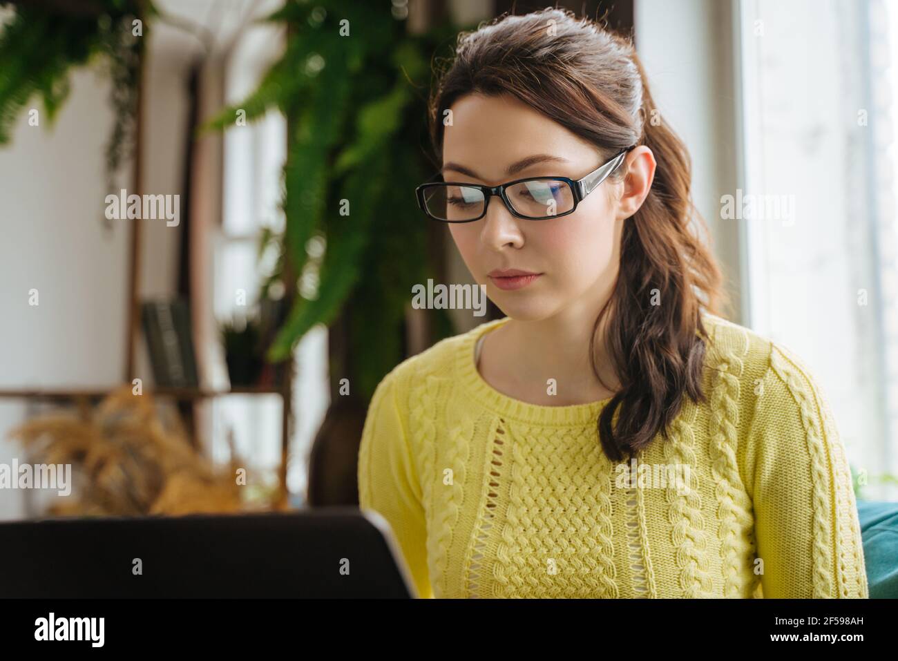 Una mujer que trabaja en un ordenador portátil en casa, el concepto de un freelancer Foto de stock