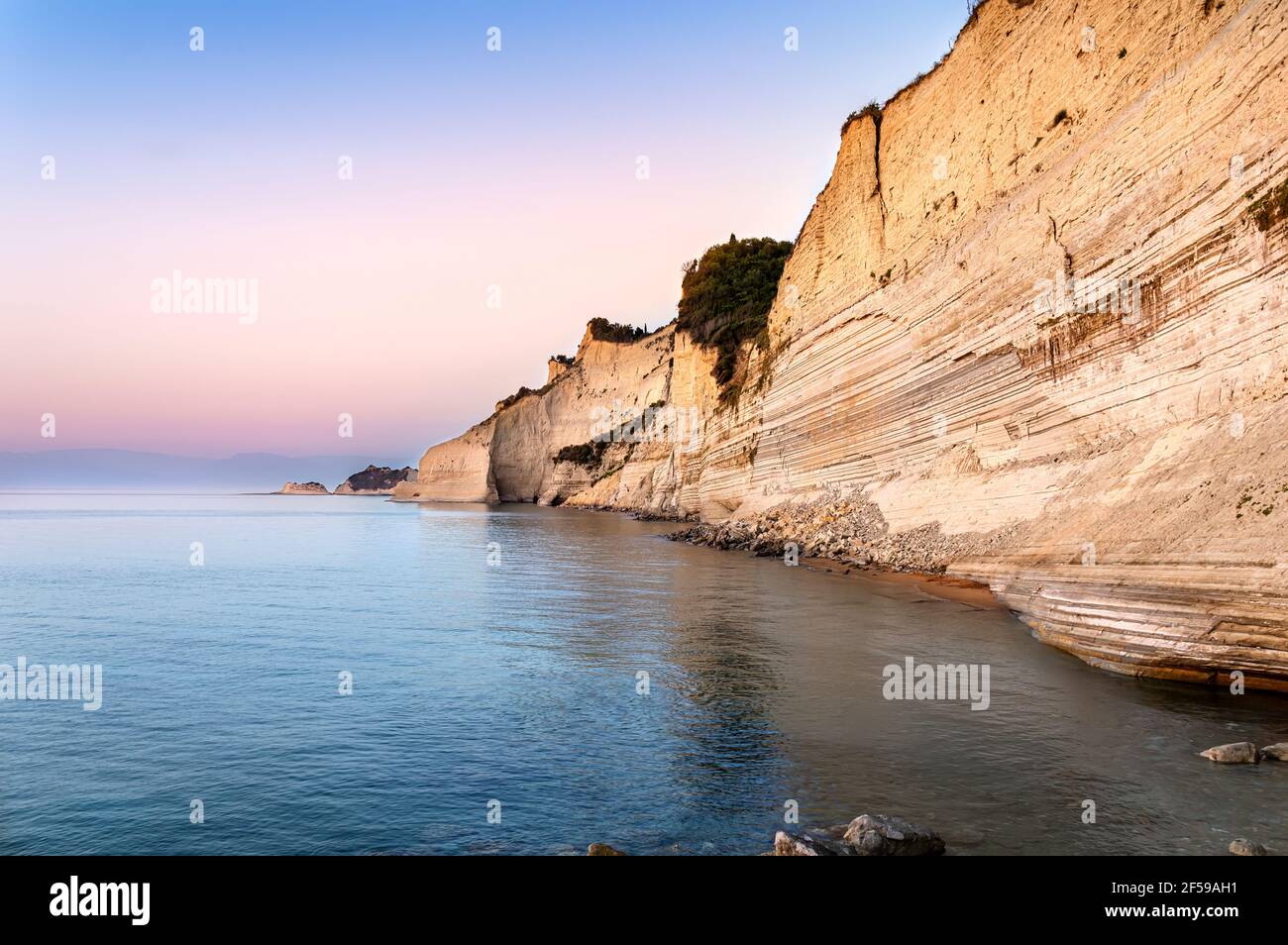 Logas Sunset Beach con acantilados blancos en el pueblo de Peroulades en la isla de Corfú en Grecia. Loggas es famoso por su mirador panorámico con vistas al mar al atardecer Foto de stock