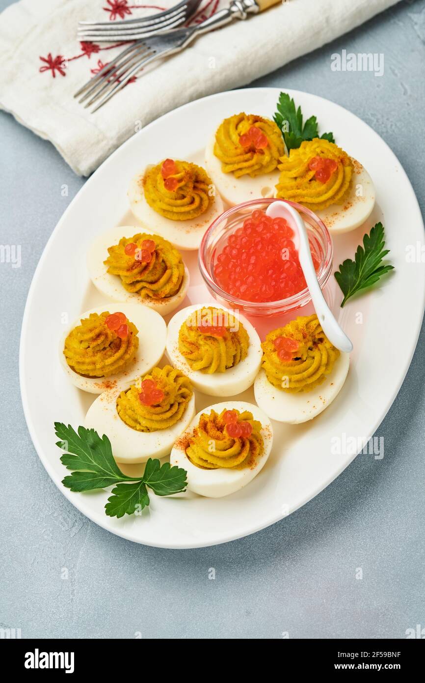 Huevos rellenos con caviar rojo y pimentón en un plato para la mesa de  pascua de aperitivo, vista superior, espacio de copia. plato tradicional  para felices fiestas de pascua.