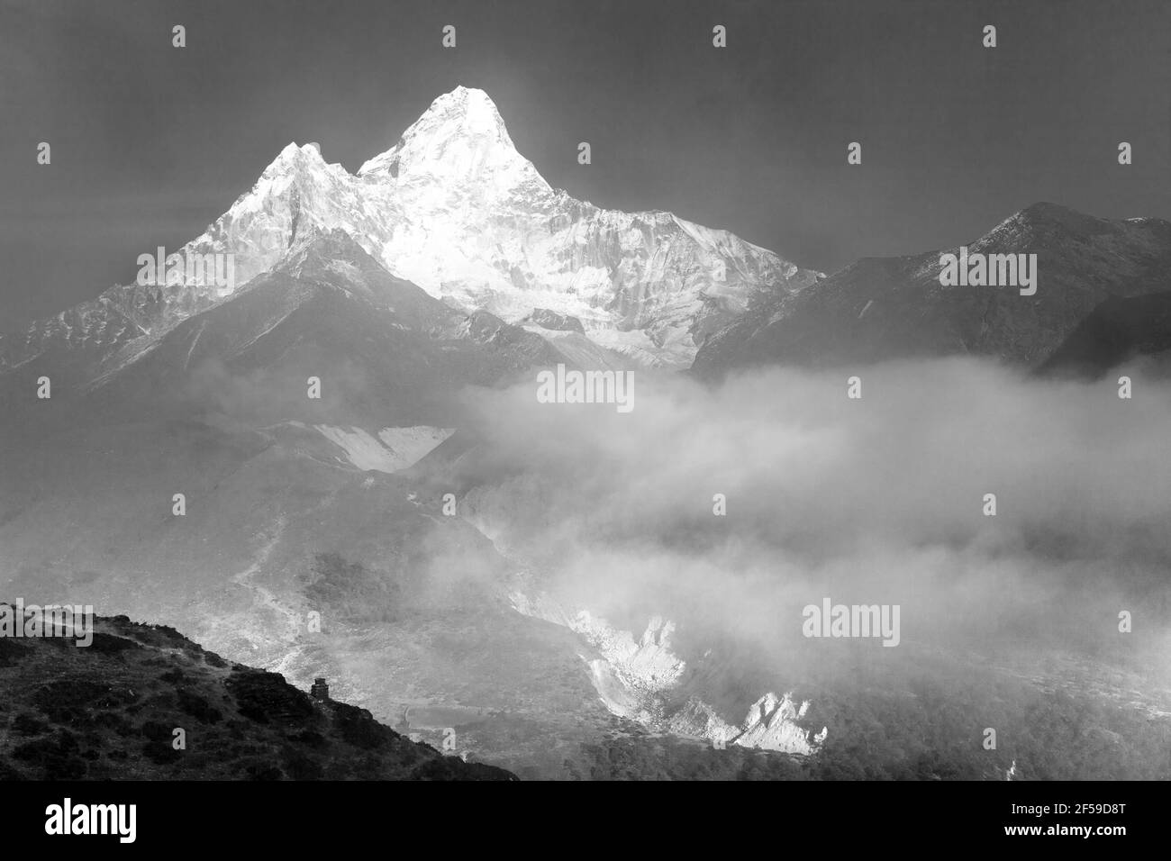 Monte Ama Dablam dentro de las nubes, vista en blanco y negro, camino al campamento base Everest, valle Khumbu, parque nacional Sagarmatha, área Everest, Nepal Foto de stock