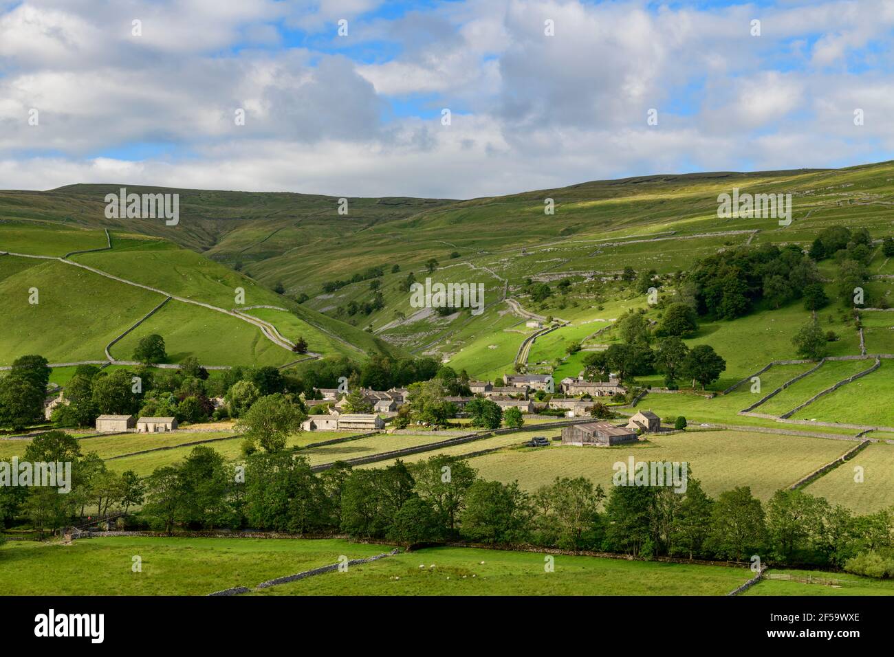 Pintoresco pueblo de Dales (casas de piedra) situado en el valle iluminado por el sol por campos, colinas, laderas y garganta empinada - Starbotton, Yorkshire Inglaterra Reino Unido. Foto de stock