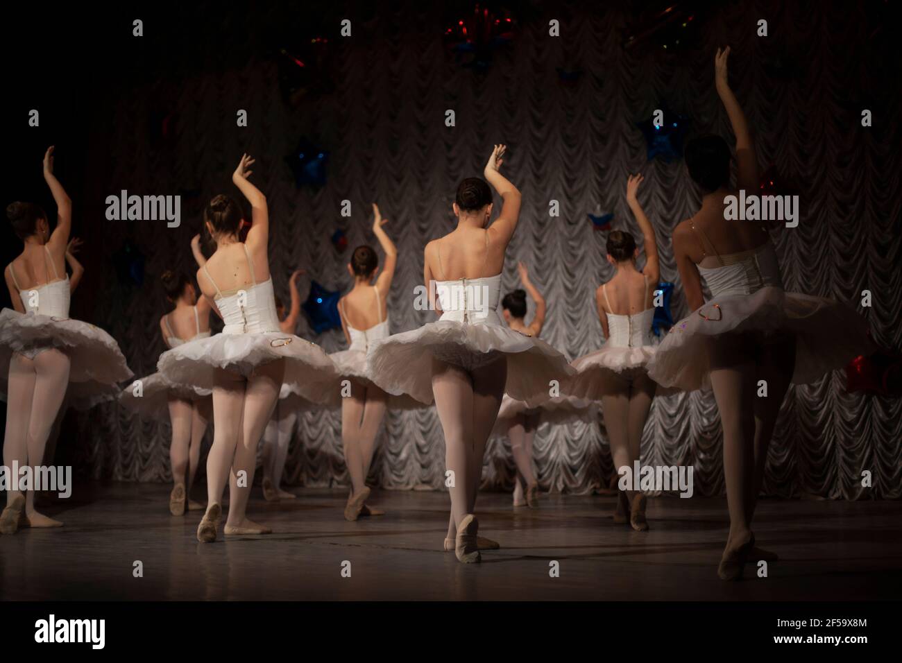 Bailarinas en tutus blanco muestran movimiento de baile. Las chicas están haciendo ballet. Clase de danza de ballet en el escenario. Hay muchas niñas en hermosos vestidos. Gra Fotografía de stock - Bailarinas en tutus blanco muestran movimiento de baile. Las chicas están haciendo ballet. Clase de danza de ballet en el escenario. Hay muchas niñas en hermosos vestidos. Gra Fotografía de stock -