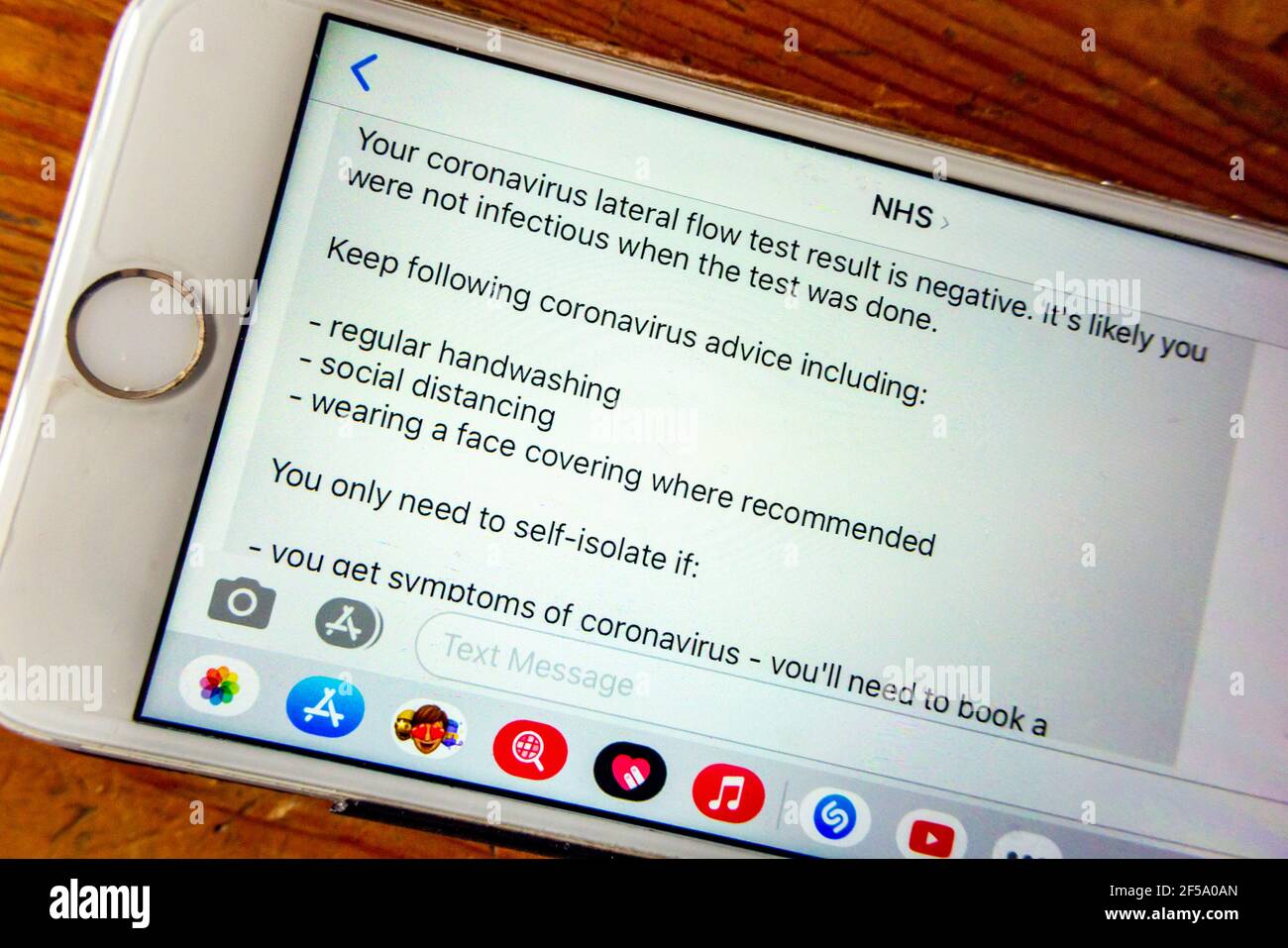 Teléfono móvil que muestra los resultados negativos de un lateral coronavirus Prueba de flujo enviada desde el NHS durante el tercer Reino Unido bloqueo de la pandemia en 2021 Foto de stock