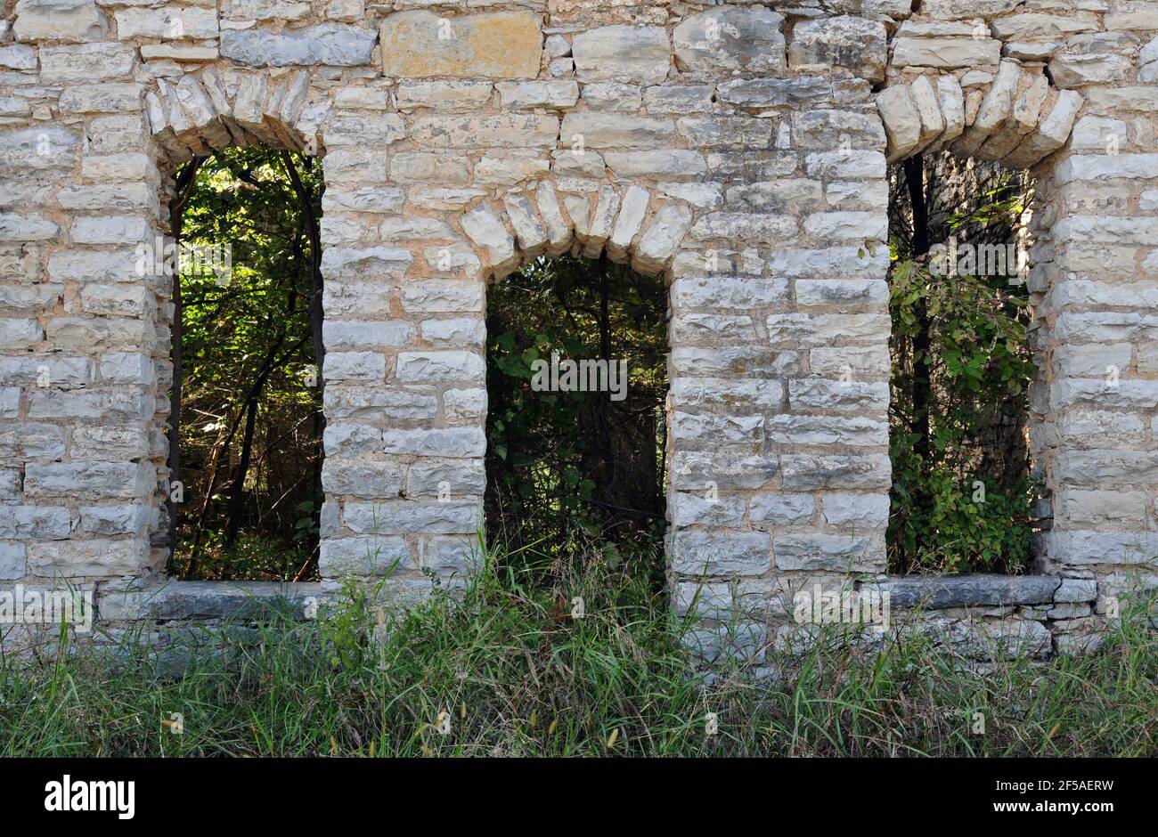 La puerta de piedra arqueada y ventanas en las ruinas de una antigua tienda general en la antigua Ruta 66 en plano, Missouri. Foto de stock