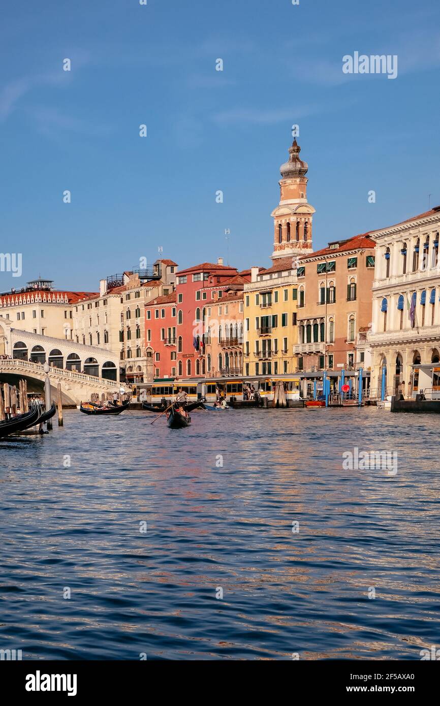Gondolier, Puente de Rialto y los turistas en Gondolas en el Gran Canal con las tradicionales casas de colores venecianos - mañana tranquila en Venecia, Veneto, Italia Foto de stock