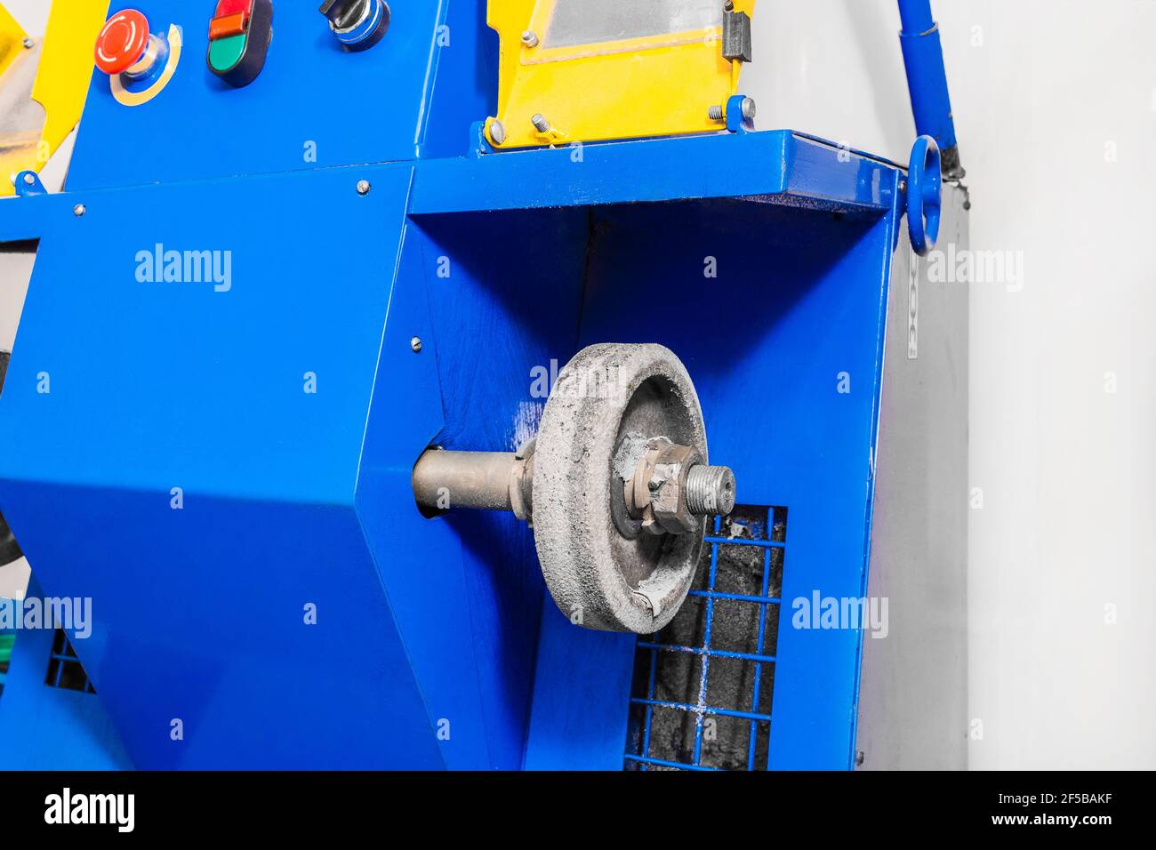 Máquina de molienda con rueda de fieltro para pulir y procesar zapatos en una tienda de zapatos de una empresa industrial. Foto de stock