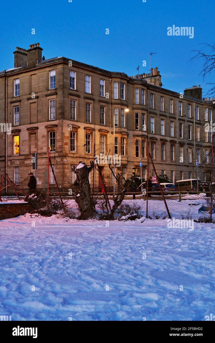 Glasgow se pone al atardecer con nieve de invierno. Foto de stock