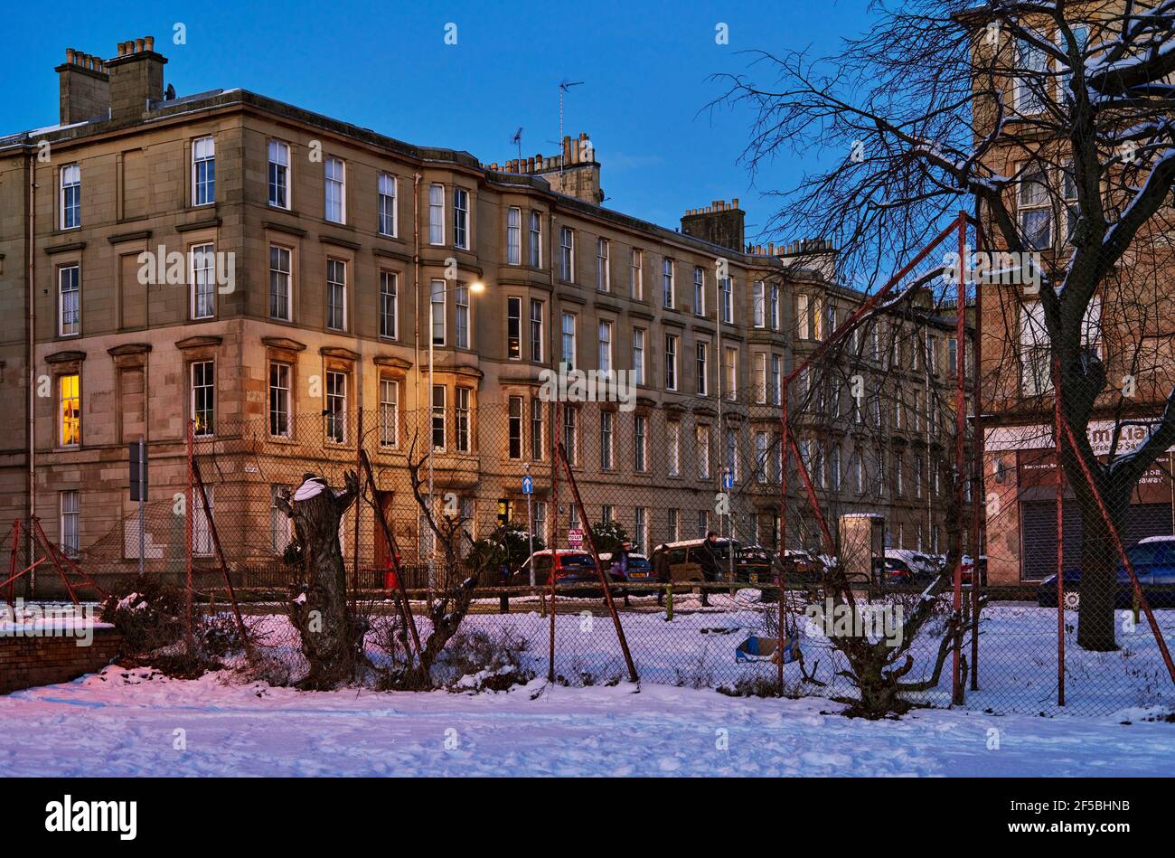 Glasgow se pone al atardecer con nieve de invierno. Foto de stock
