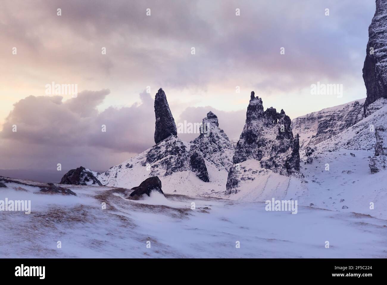 Old Man Storr, Isle Skye, Escocia. Invierno, montaña muy nevada en un amanecer muy potente. La primera mañana se ilumina entre las nubes Foto de stock