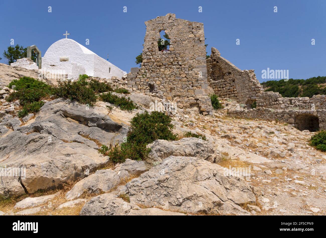 Patio de la fortaleza de Monolithos con la Iglesia Ortodoxa y las ruinas de la torre (Rodas, Grecia) Foto de stock
