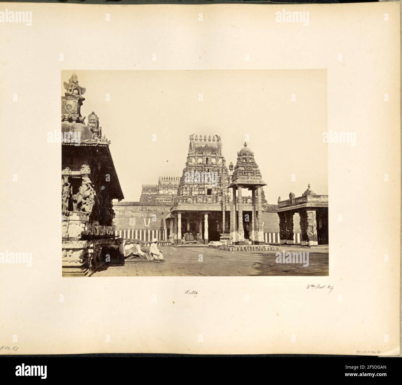 Conjivoram en Madras. Vista de un patio en el templo Varadharaja Perumal en Kanchipuram. Un beso alto y estrecho con cuatro columnas talladas y un techo tallado en forma de campana se encuentra en el centro del patio frente a la gopura, o pirámide de la puerta del templo. Un pórtico de piedra, o mandapa, rodea la gopura, y dos edificios adicionales, ornately tallado se encuentran en los lados derecho e izquierdo del patio. (Recto, Mount) parte inferior izquierda, escrita a mano en lápiz: 'A42,81 (Bou)' parte inferior central, escrita a mano en tinta negra: 'ditto' parte inferior izquierda, escrita a mano en tinta negra: '8th de noviembre de 69' Foto de stock