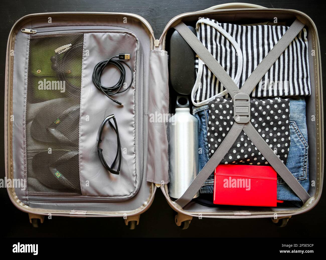 Foto Manos de mujer con tabla de viaje en el fondo de maleta abierta  empacada de Boyarkinamarina en Envato Elements