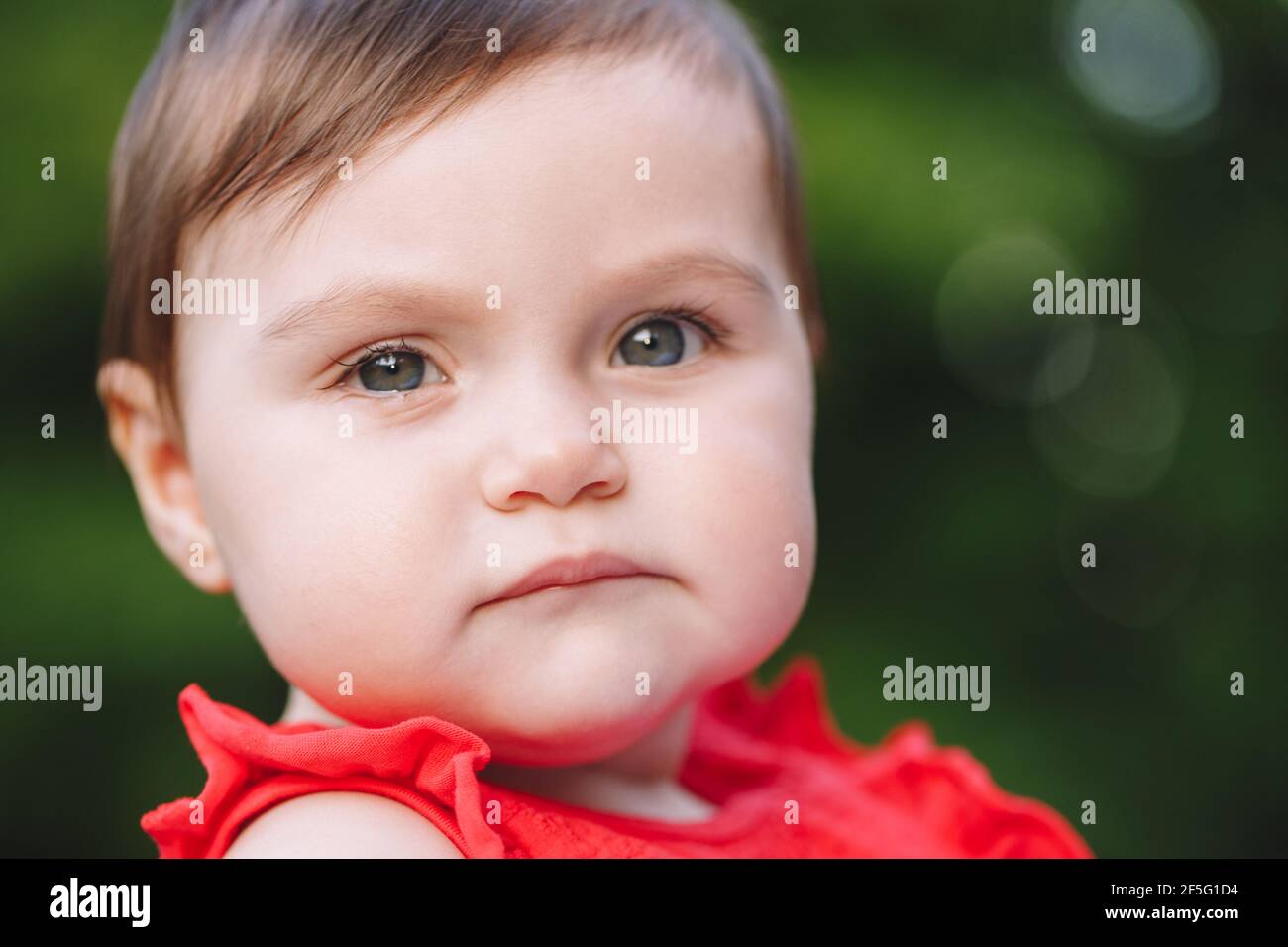 Niño divertido. Retrato de primer plano de adorable bebé caucásico con ojos  grises. Lindo niño niño bebé vestido rojo en el parque al aire libre.  Auténtico Fotografía de stock - Alamy