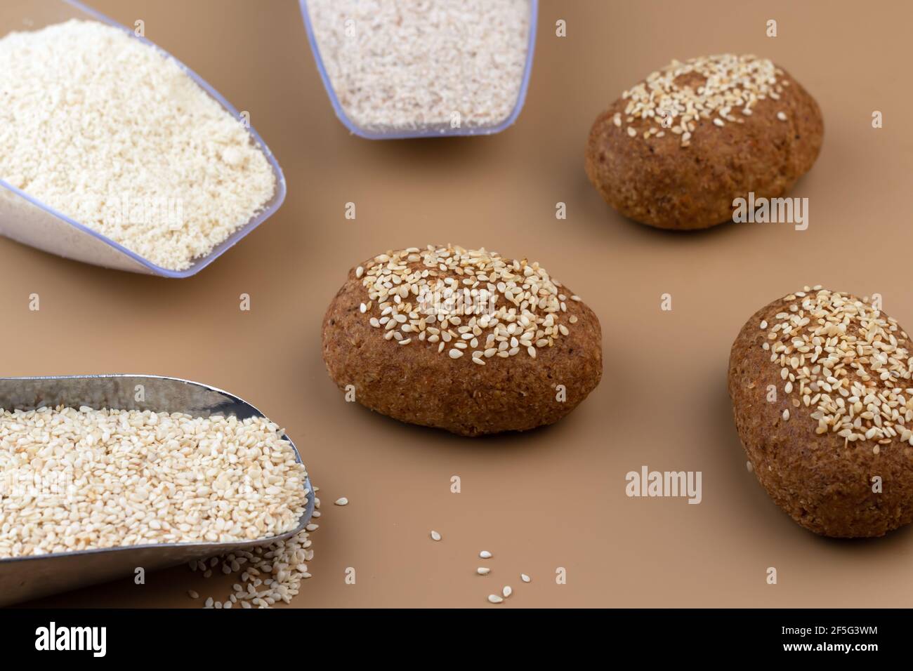 Un saludable pan de keto sin gluten hecho de harina de almendras y cáscara  de psyllium, rociado con semillas de sésamo. Horneando los ingredientes en  las palas. Dieta cetogénica Fotografía de stock -
