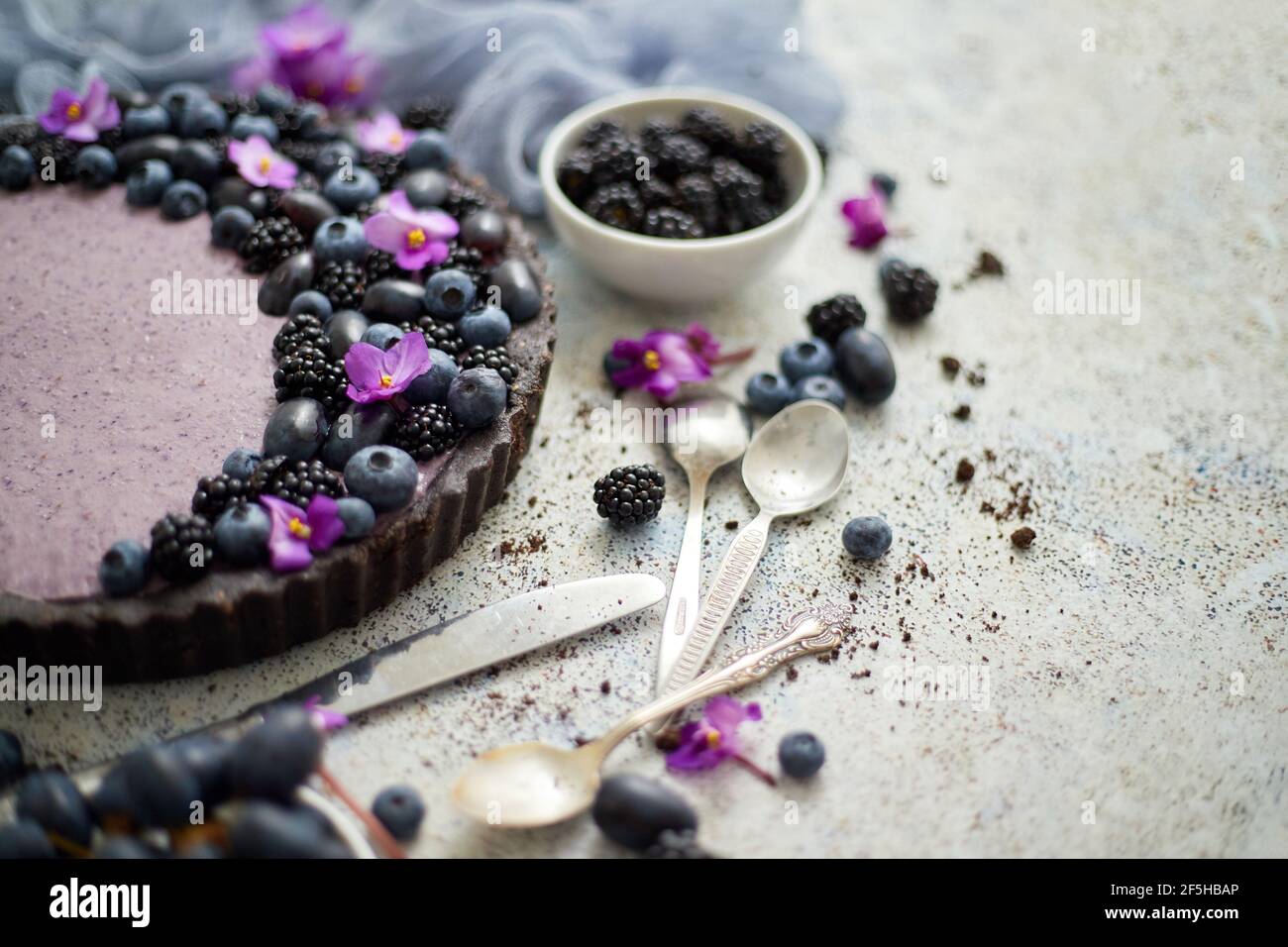 Tarta dulce y sabrosa con arándanos frescos, moras y uvas, servida sobre fondo de piedra Foto de stock