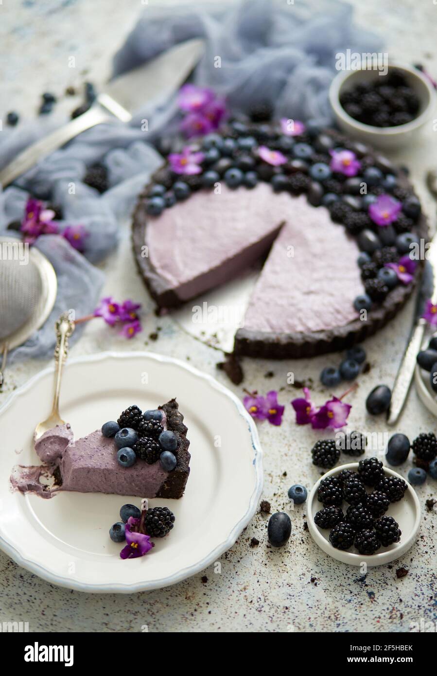 Plato con un pedazo casero de delicioso arándanos, mora y tarta de uva servida en la mesa Foto de stock