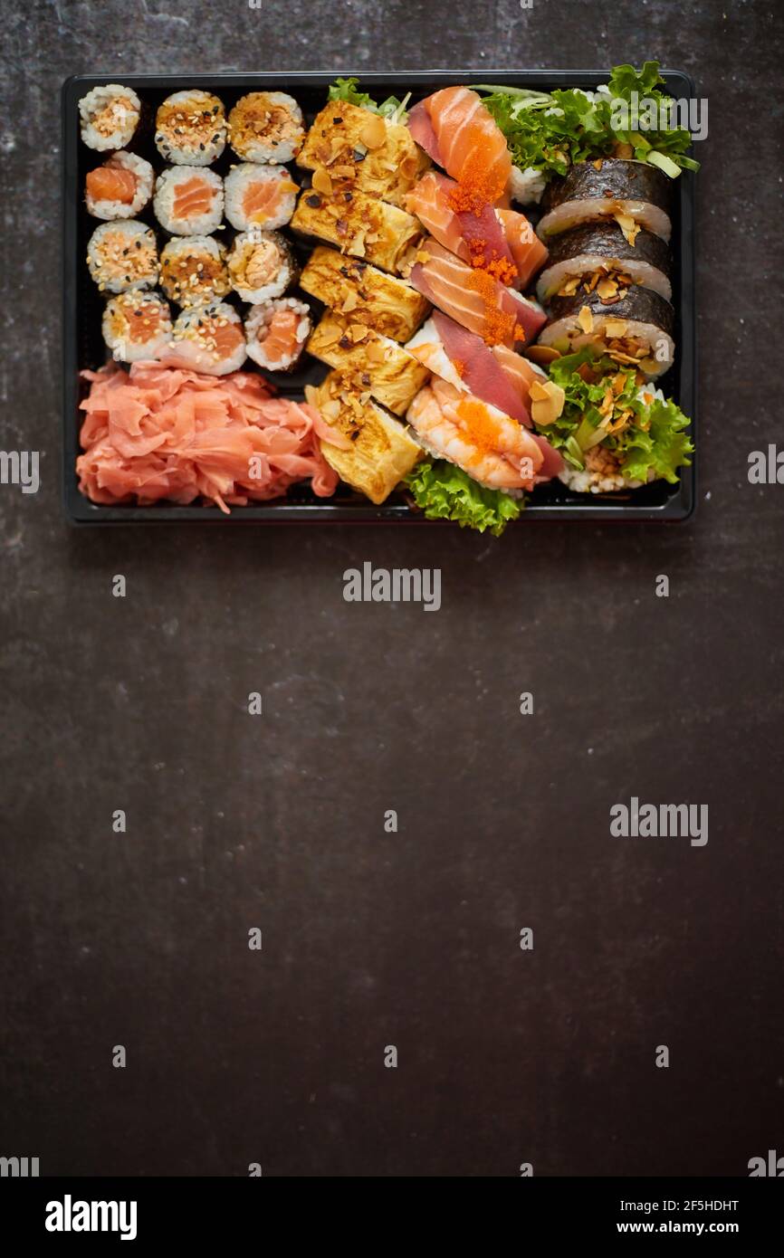 Sushi Bandeja de plástico para llevar con diferentes tipos de rollos y espacio de copia. Concepto de comida para llevar. Foto de stock