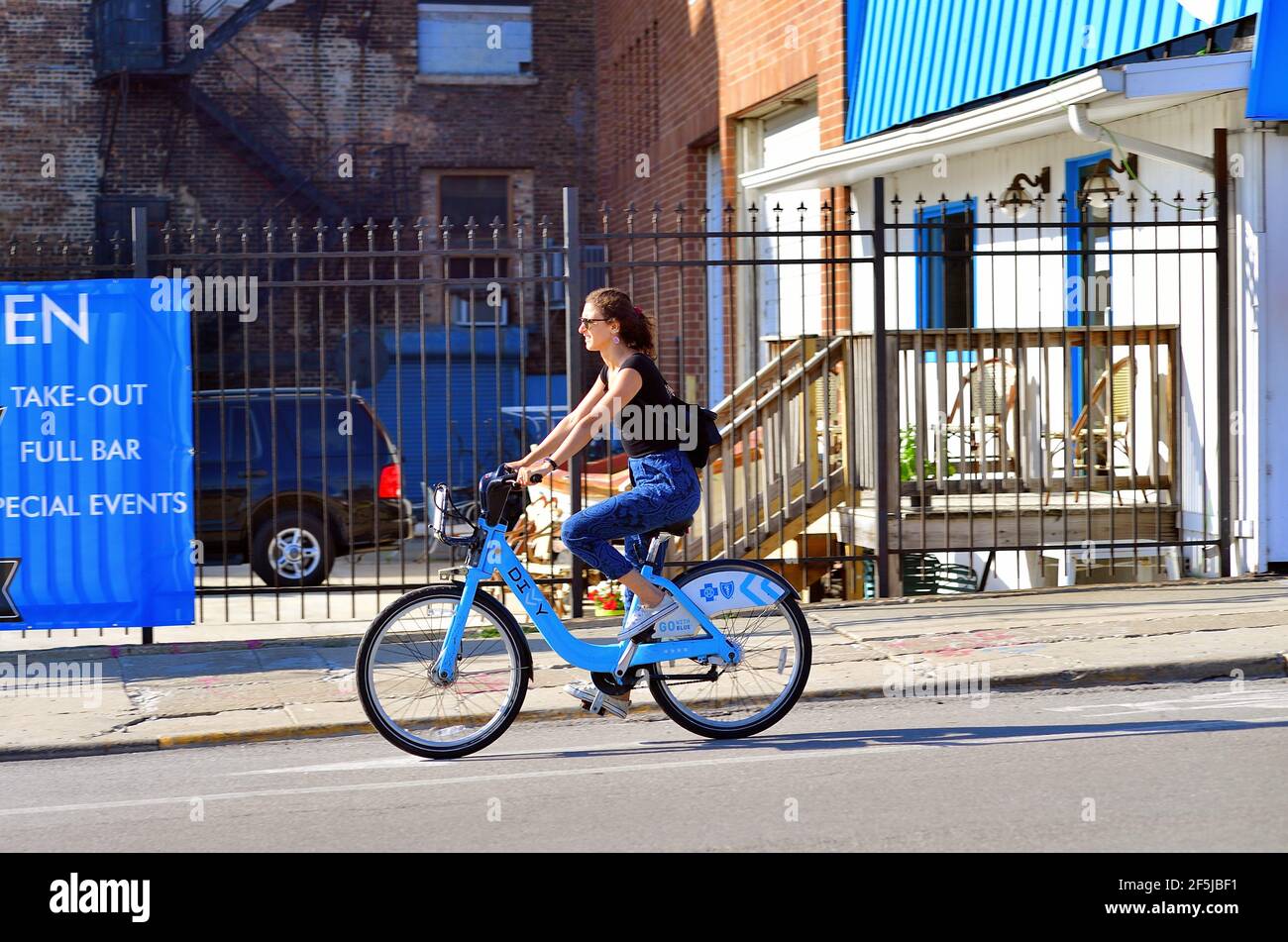 Chicago, Illinois, EE.UU. Mujer que usa una bicicleta alquilada o una  bicicleta compartida dentro de un carril designado para bicicletas  callejeras en el lado norte de la ciudad Fotografía de stock -