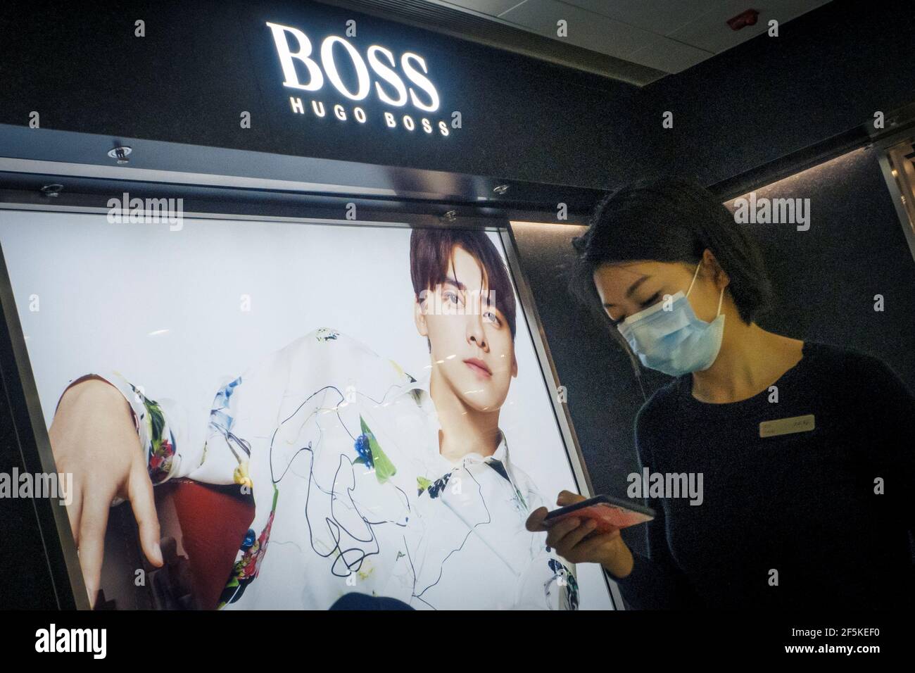 Una mujer pasa por una tienda de la casa de moda alemana Hugo Boss en  Beijing, China, 27 de marzo de 2021. REUTERS/Thomas Peter Fotografía de  stock - Alamy