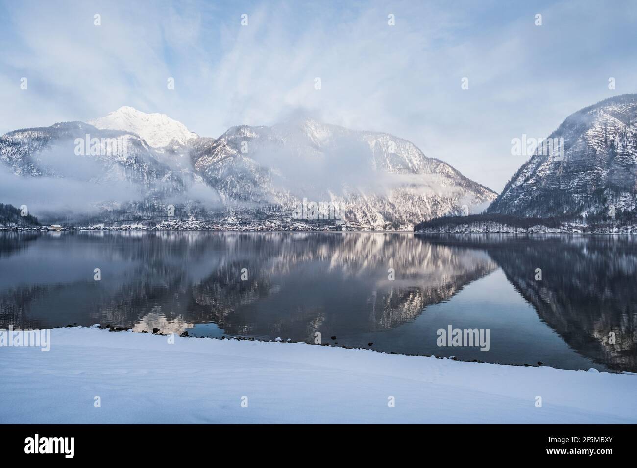 Lago Hallstatt o Hallstatter Ver en invierno en el Salzkammergut, Alta Austria, con Montañas nevadas en una fría mañana de enero Foto de stock