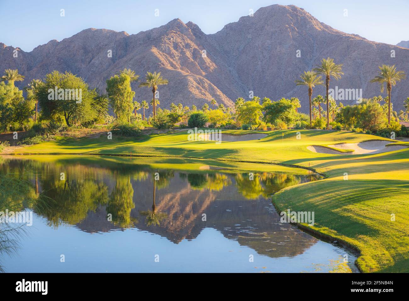 Hermosa luz dorada sobre Indian Wells Golf Resort, un campo de golf en el desierto en Palm Springs, California, Estados Unidos con vista a las montañas de San Bernadino. Foto de stock