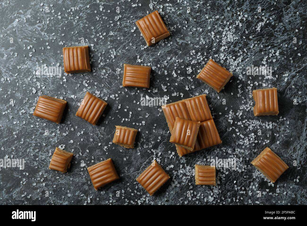 Trozos de caramelo salados sobre fondo negro ahumado Foto de stock