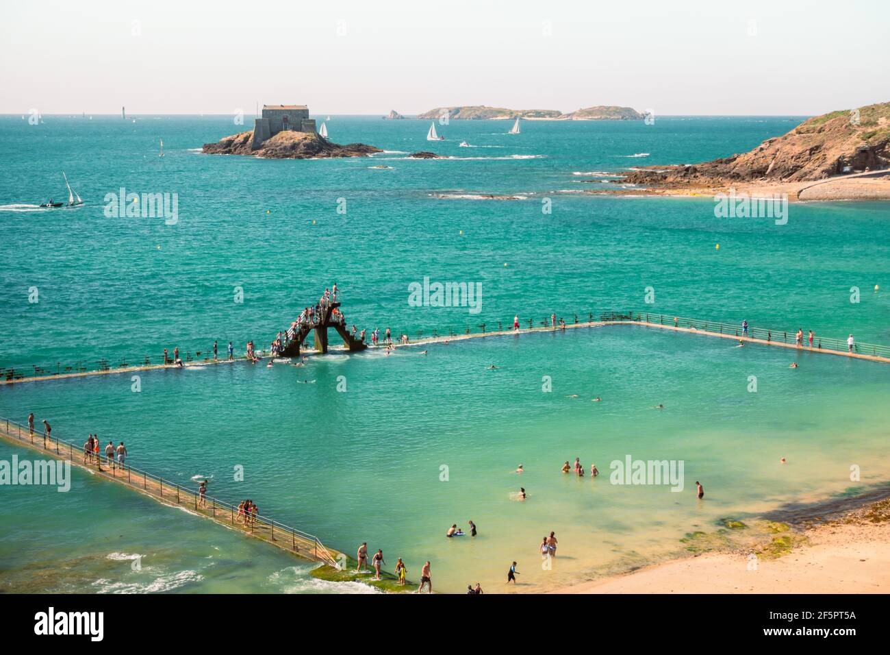 Playa, gente y mar abierto piscina y trampolín en Saint Malo, Francia Foto de stock