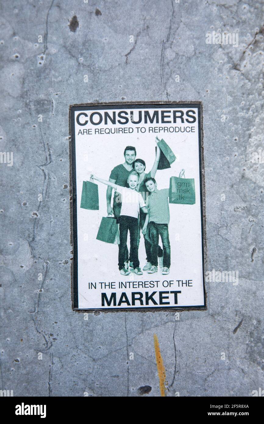 Los consumidores están obligados a reproducirse en interés del mercado. Pegatina anticonsumerista en un poste de luz de aluminio. Foto de stock