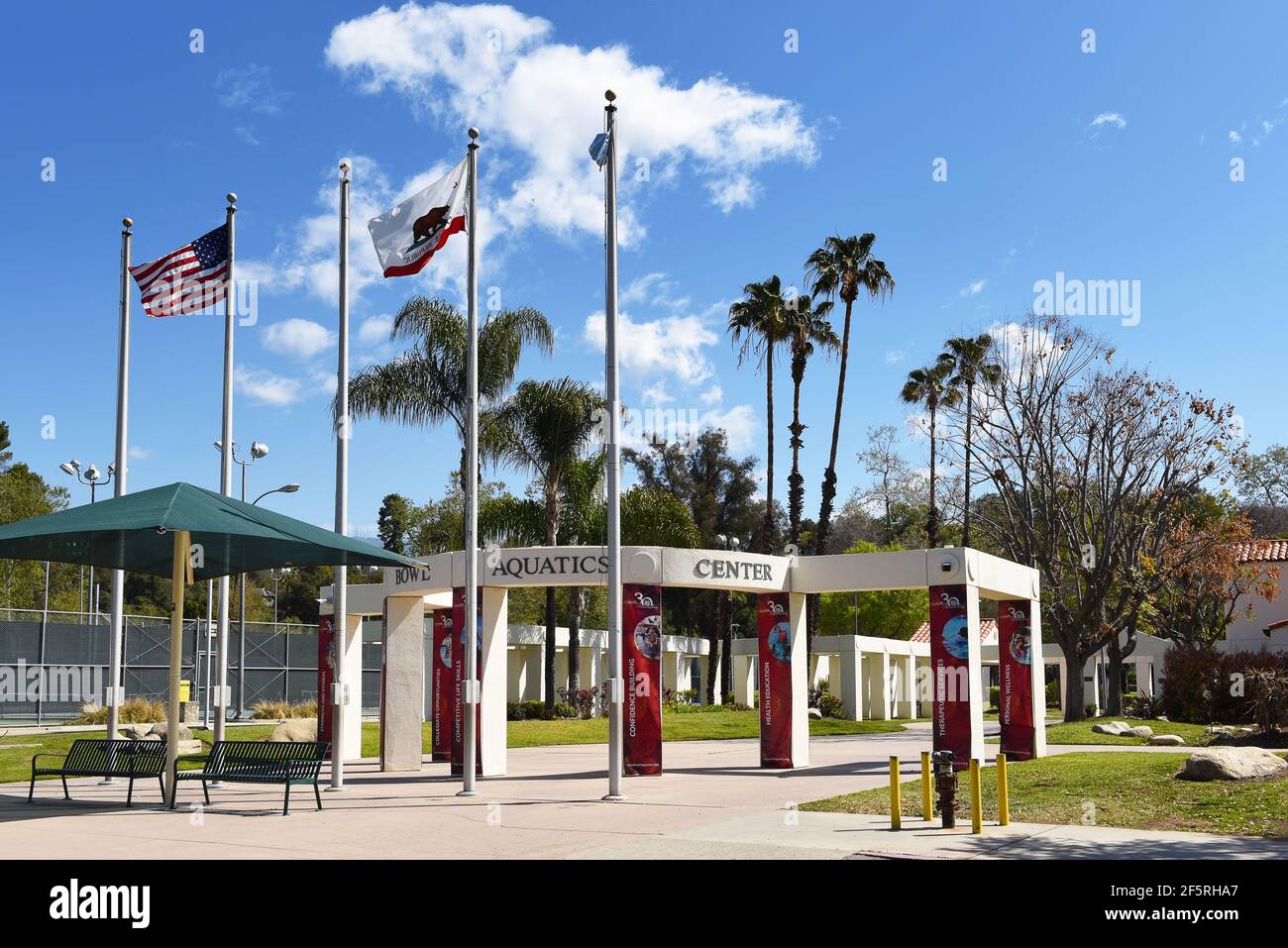 PASADENA, CALIFORNIA - 26 MAR 2021: Banderas de una bandera en la entrada del Rose Bowl Aquatics Center en Brookside Park. Foto de stock