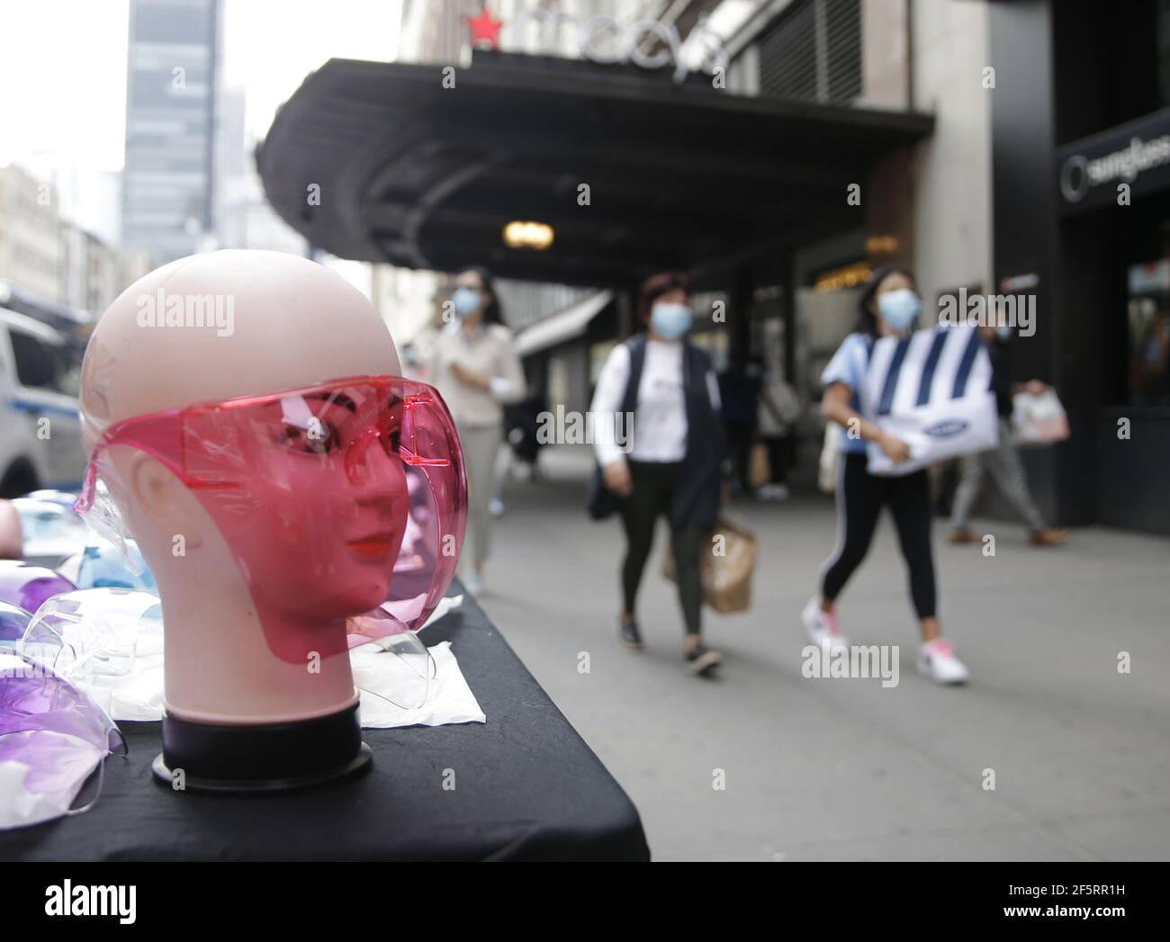 Nueva York, Estados Unidos. 27th de marzo de 2021. Los peatones usan máscaras mientras caminan por una exhibición de escudos para la venta en la ciudad de Nueva York el sábado, 27 de marzo de 2021. Foto de John Angelillo/UPI crédito: UPI/Alamy Live News Foto de stock