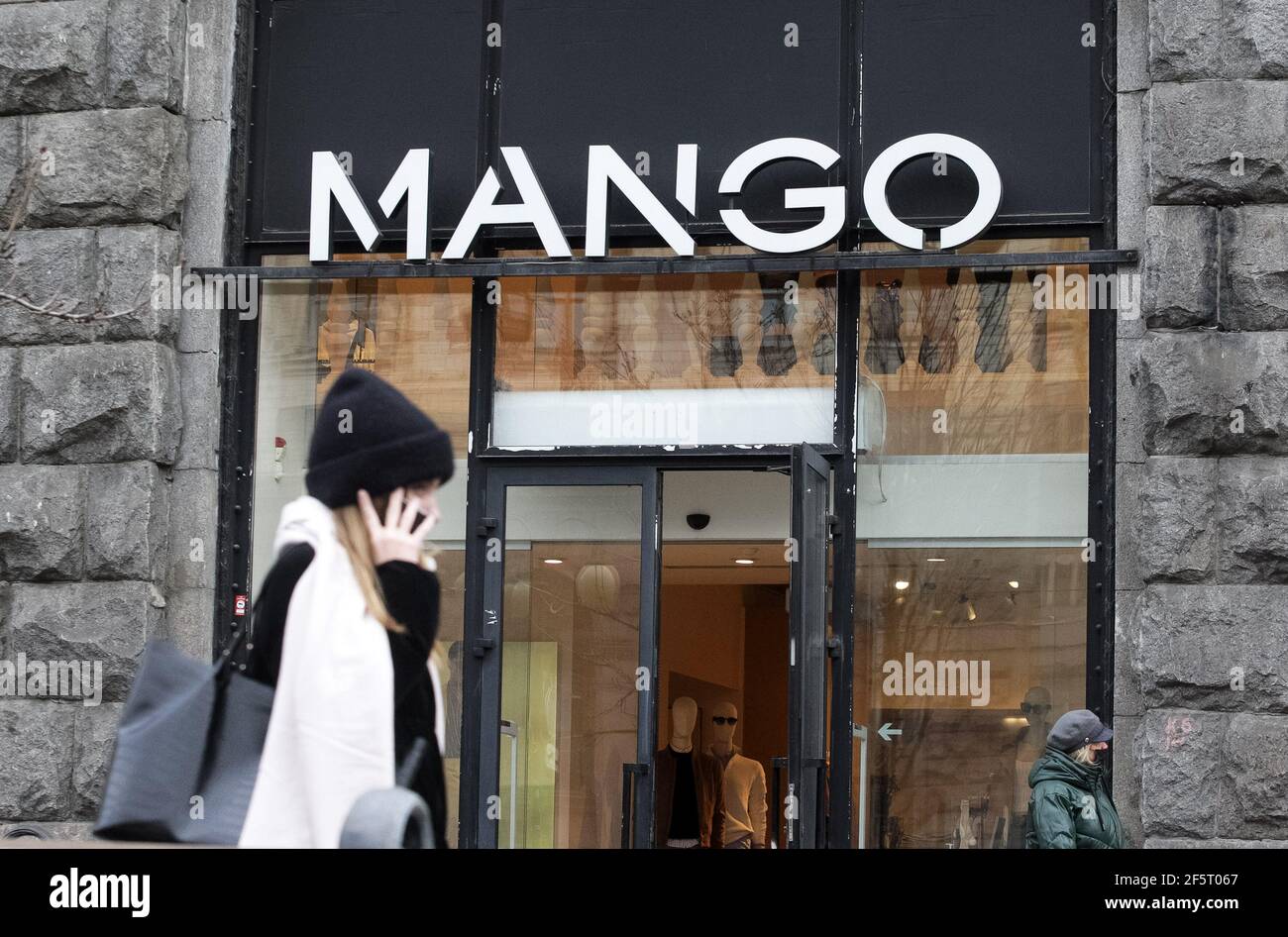 El logotipo de mango de una empresa española de diseño y fabricación de ropa se ve en la entrada a una tienda de la Marca en Kiev Fotografía de stock -