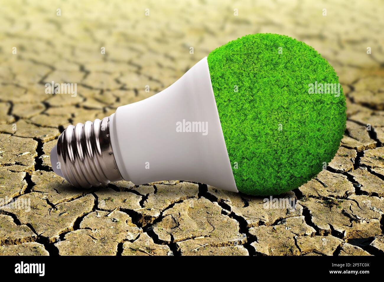 Bombilla LED ECO sobre tierra seca agrietada. Conceptos de conservación ambiental, calentamiento global o energía limpia. Foto de stock
