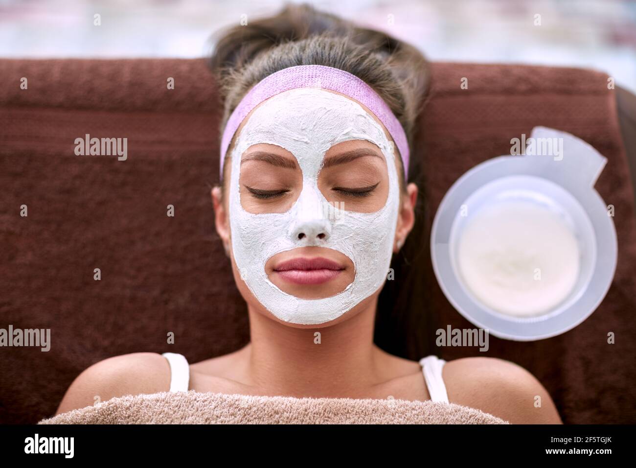 Mascarilla facial cosmética que se aplica en la cara de la mujer hermosa  con ojos cerrados Fotografía de stock - Alamy