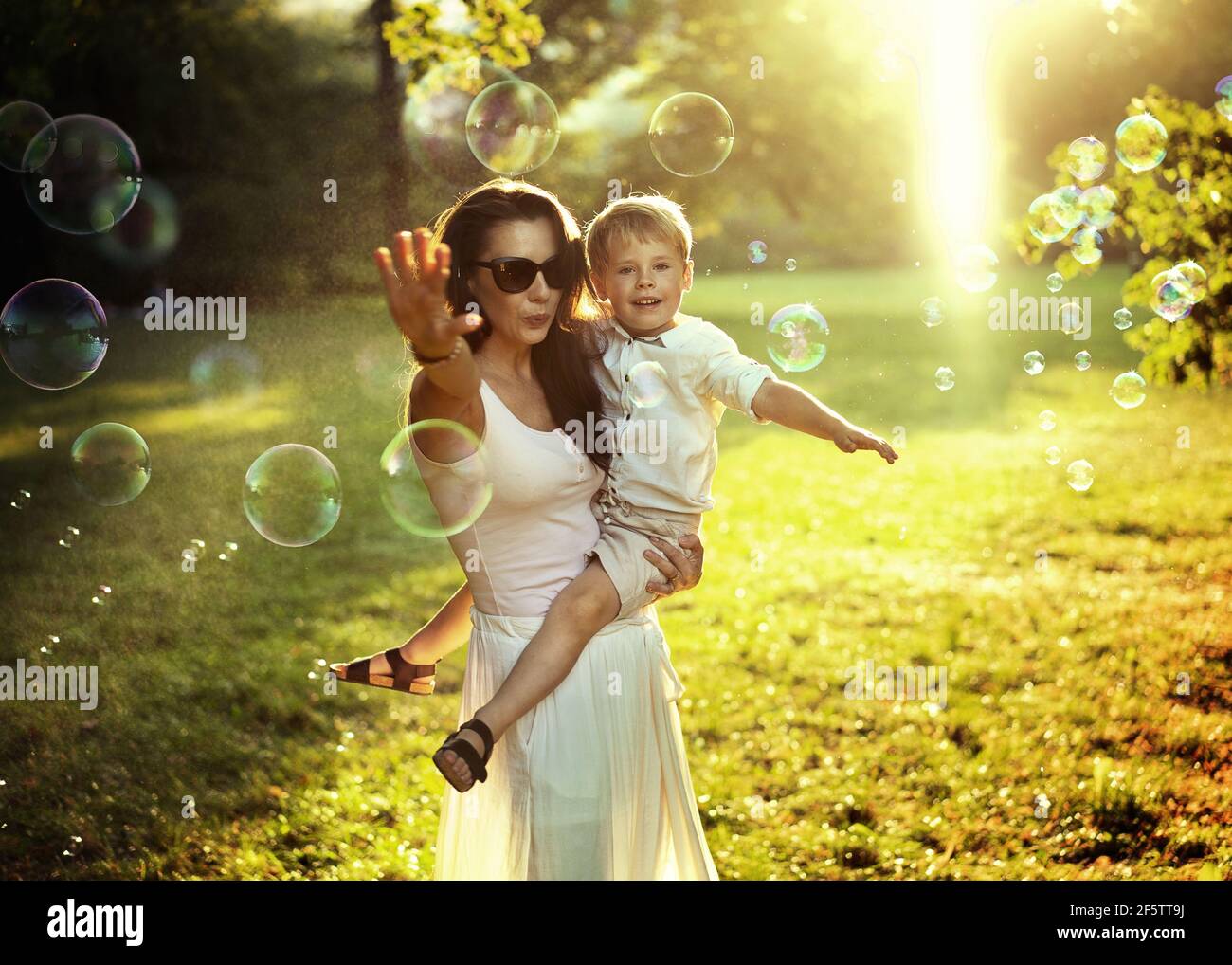 Bonita mamá llevando a su amado hijo Foto de stock