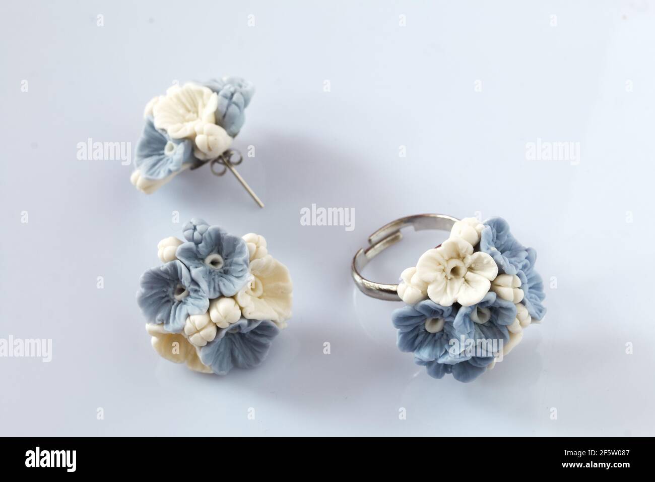 Joyería hecha a mano. Pendientes y anillo de arcilla polimérica. Se  encuentra sobre una superficie blanca Fotografía de stock - Alamy