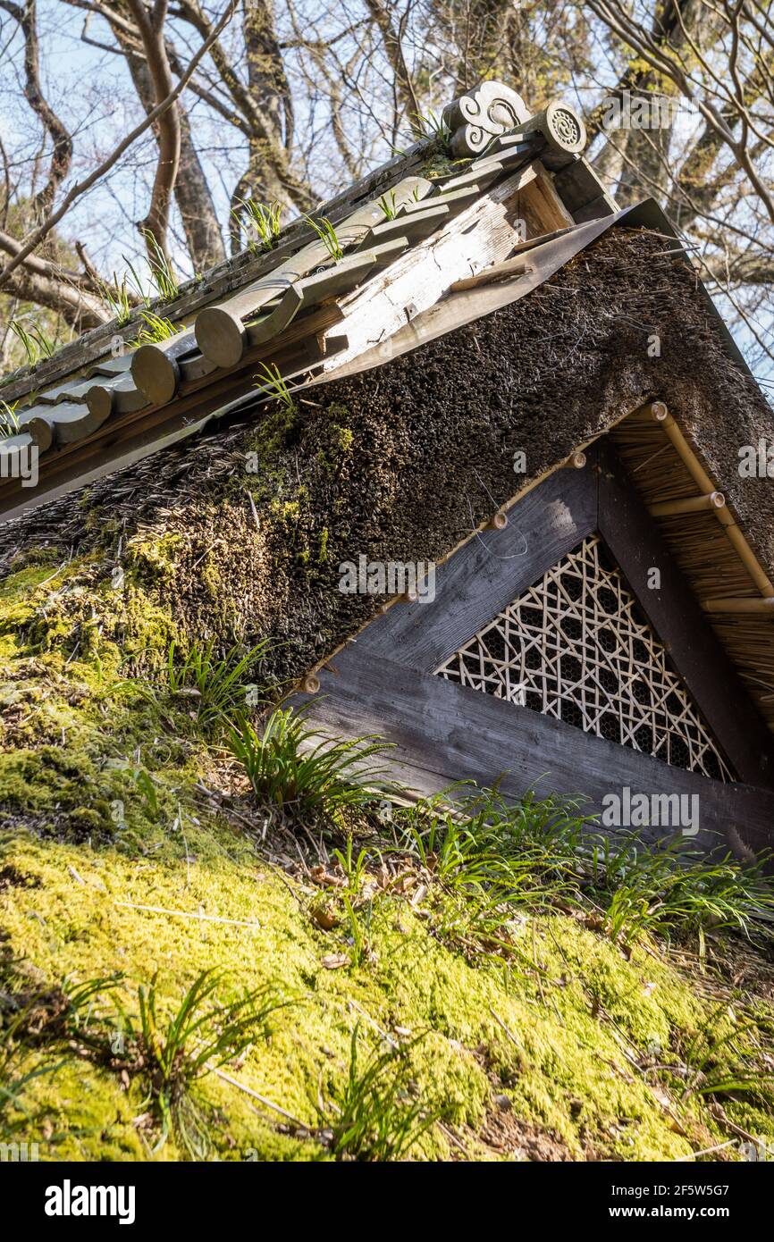 Detalle de una rejilla de ventilación en un techo tradicional japonés de madera con techo de paja cubierto de musgo en una antigua casa de té en Nara, Japón Foto de stock