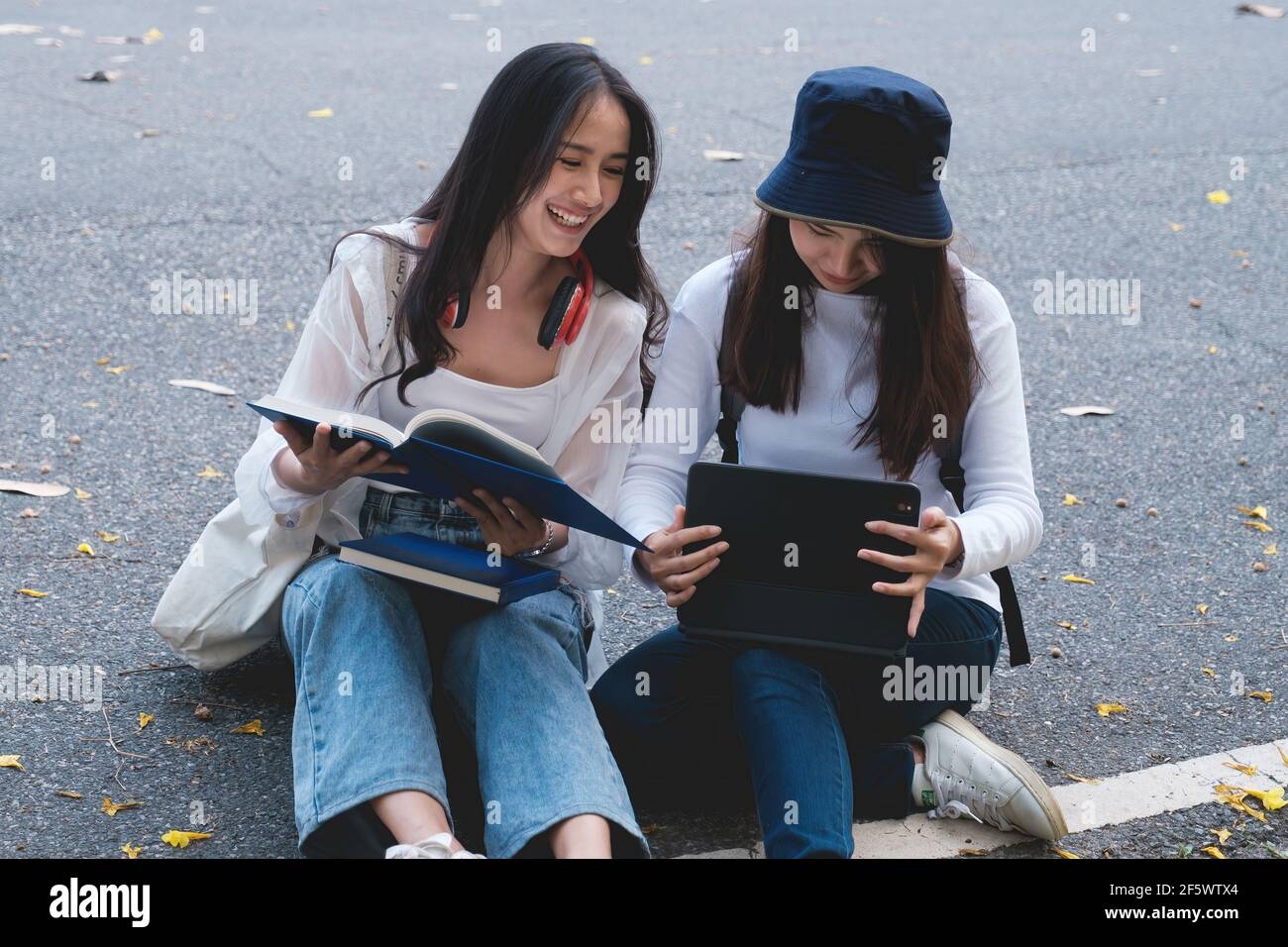 Dos estudiantes están sentados en la universidad durante la lectura de un libro y la comunicación. Estudio, educación, universidad, universidad, concepto de posgrado. Foto de stock