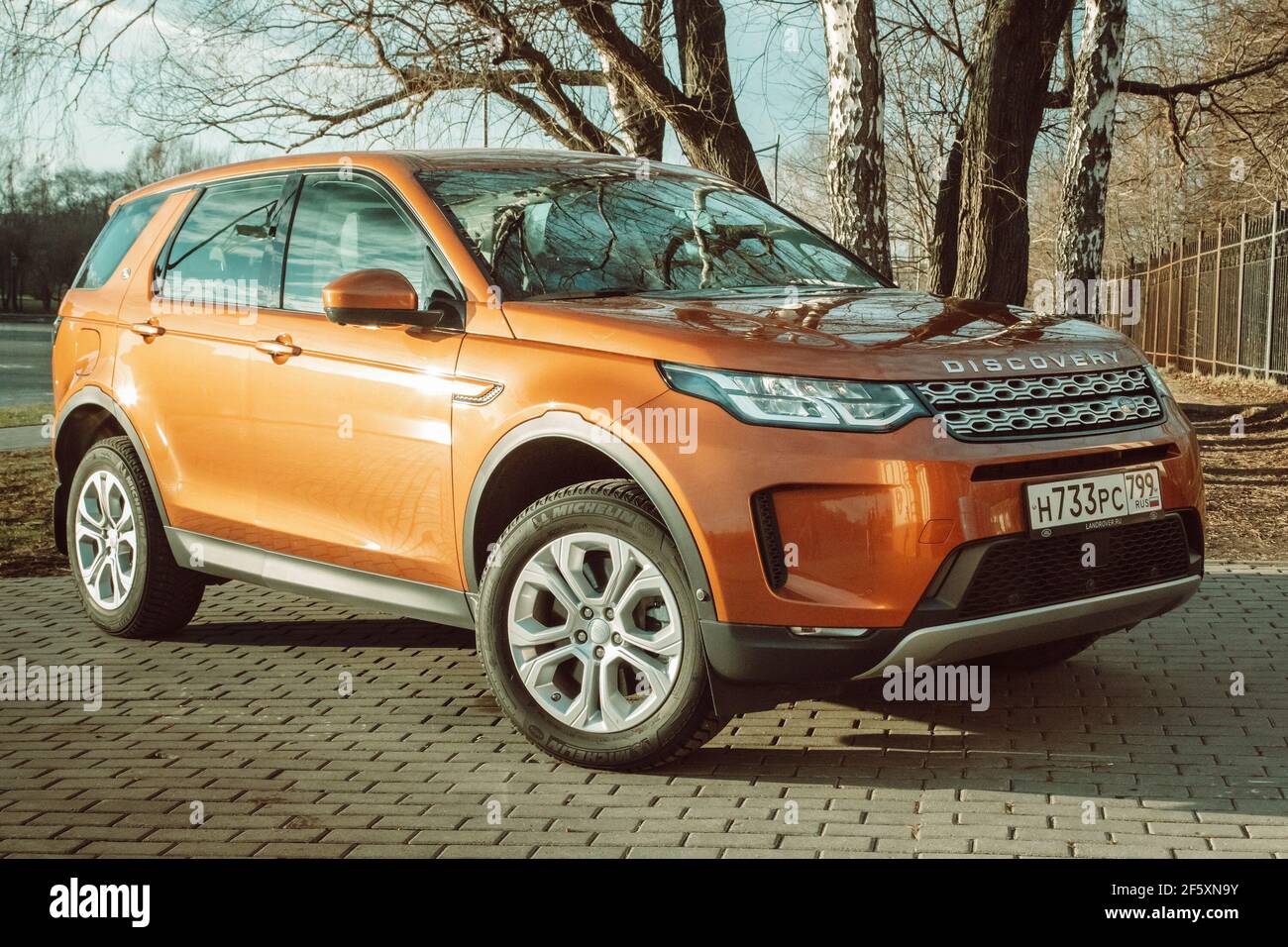 Moscú, Rusia - 20 de diciembre de 2019:el nuevo Land Rover Discovery Sport 2020 está estacionado en la costa. Exterior del SUV naranja inglés premium. Vista frontal de tres cuartos. Coche con tracción total... Foto de stock