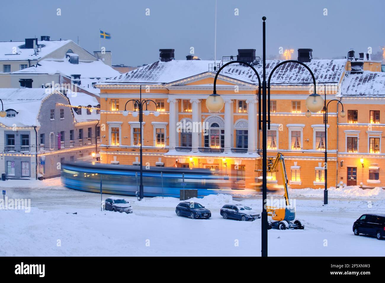 Helsinki, Finlandia - 13 de enero de 2021: El tranvía se mueve en la Plaza del Senado durante la fuerte tormenta de nieve. Foto de stock