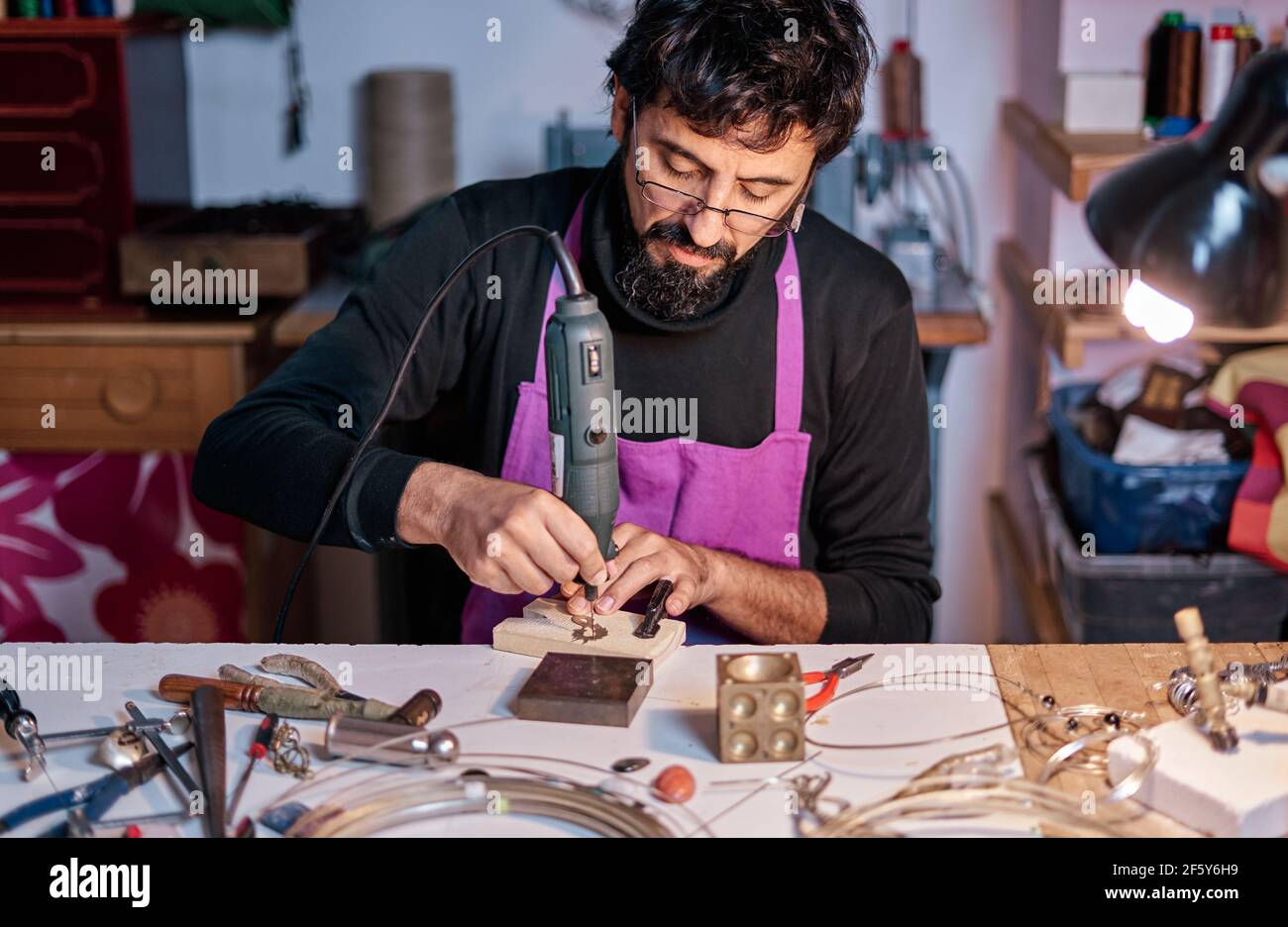 Joyero artesano trabajando con un taladro en la mesa de trabajo Fotografía  de stock - Alamy