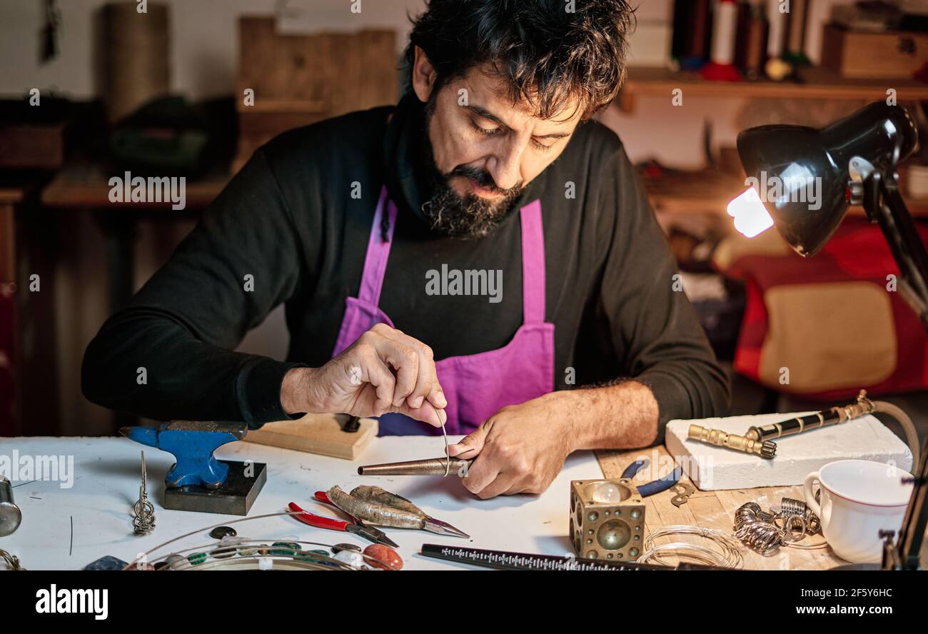 Artesano joyero trabajando en mesa de trabajo dentro del taller Fotografía  de stock - Alamy