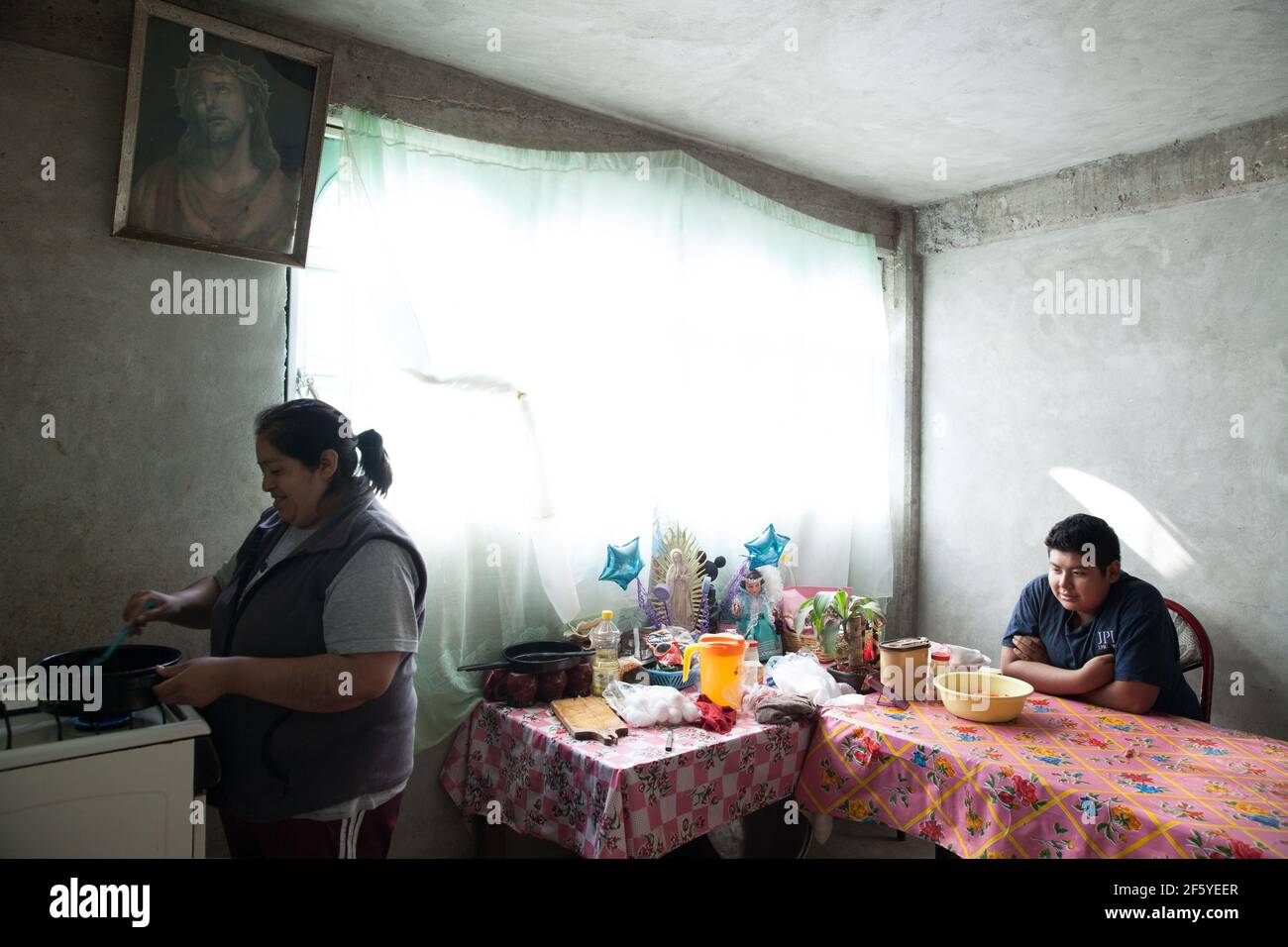 Ubaldo Alexis García López, un niño mexicano de 14 años, come el almuerzo con su madre Yolanda, en su casa en Iztapalapa, uno de los barrios más pobres de la Ciudad de México, México, el 25 de junio de 2015. Ubaldo pesa 190 libras y mide 176 centímetros. En 2011, Ubaldo pesó 169 libras y tenía 145 centímetros de altura, con un IMC de 36,5. Estaba cerca de morir debido a una serie de enfermedades relacionadas con la obesidad mórbida y fue admitido en la sala de urgencias del Hospital Infantil Federico Gómez de la Ciudad de México, donde fue diagnosticado con apnea obstructiva crónica del sueño grave, hipopnea, síndrome metabólico X. Foto de stock