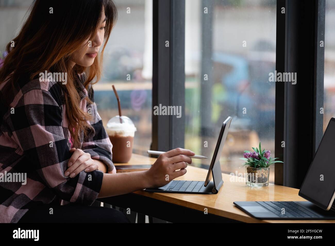 Joven diseñador creativo sosteniendo el lápiz de lápiz de dibujo en la pantalla de tableta digital en el café Foto de stock