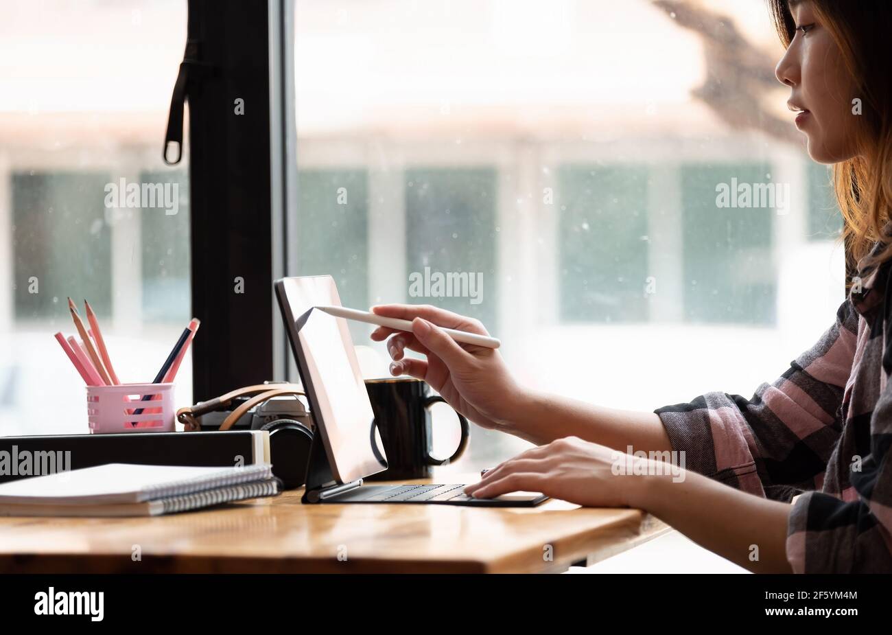 Asian Graphic Designer trabaja con un monitor interactivo, una tableta de dibujo digital y un lápiz Foto de stock
