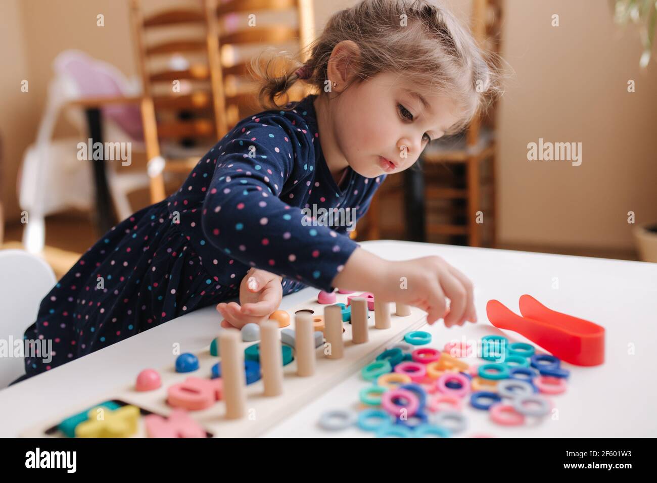 niñas juegan en juegos educativos para niños. Juego de madera con diferentes colores y números. Juego de intecactive para niños inteligentes. La chica pasó tiempo en Fotografía de stock - Alamy