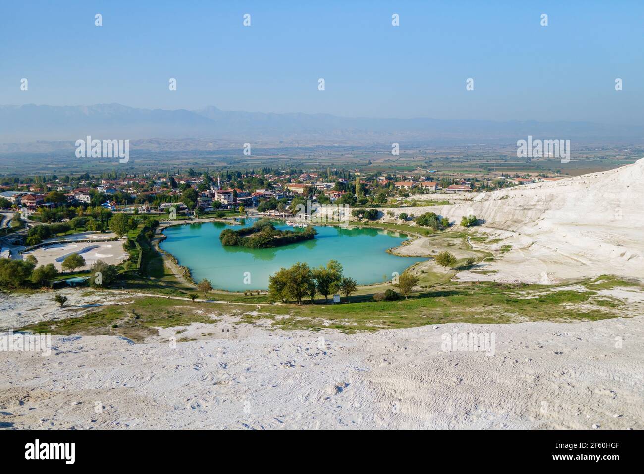 Vista panorámica sobre el lago cerca del pie de los famosos travertinos de Pamukkale (Turquía) y la ciudad en sí. Color verde y azul del agua formada por agua mineral Foto de stock