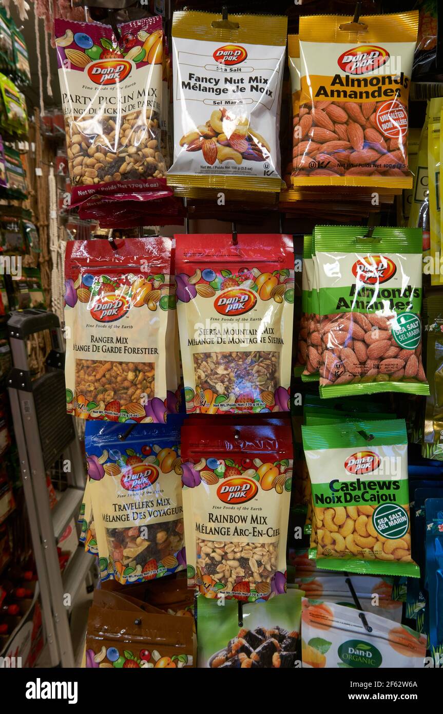 Paquetes de frutos secos mezclados colgados en un rack una tienda Foto de stock